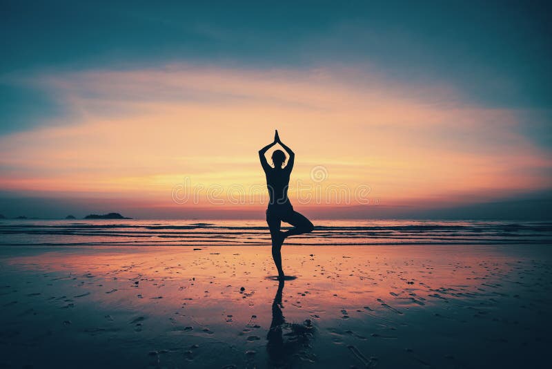 Yoga de pratique de jeune femme de silhouette sur la plage photos libres de droits Yoga de pratique de jeune femme de silhouette sur la plage photos libres de droits
