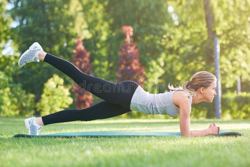 Yoga de pratique de jeune femme dehors au parc images libres de droits Yoga de pratique de jeune femme dehors au parc images libres de droits
