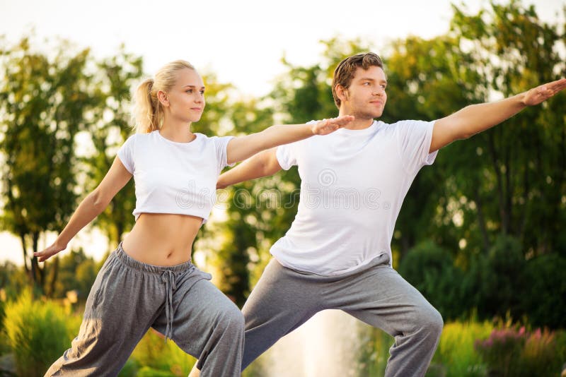 Yoga de pratique de jeunes couples photo libre de droits Yoga de pratique de jeunes couples photo libre de droits