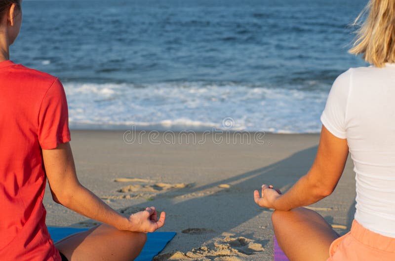 Yoga de pratique de femme et méditer sur la plage Main femelle en gros plan en position de mudra et de lotus image stock Yoga de pratique de femme et méditer sur la plage Main femelle en gros plan en position de mudra et de lotus image stock