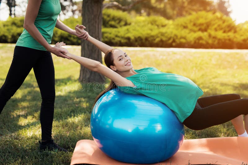 Yoga del embarazo Una mujer está haciendo ejercicios en una bola azul para la yoga El coche le ayuda foto de archivo Yoga del embarazo Una mujer está haciendo ejercicios en una bola azul para la yoga El coche le ayuda foto de archivo