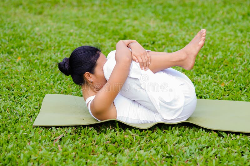 Yoga di pratica della bella donna nel parco immagini stock libere da diritti Yoga di pratica della bella donna nel parco immagini stock libere da diritti