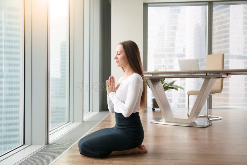 Yoga di pratica della giovane donna nell'ufficio fotografia stock libera da diritti Yoga di pratica della giovane donna nell'ufficio fotografia stock libera da diritti