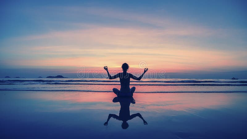 Yoga, forma fisica, stile di vita sano Profili la ragazza di meditazione sui precedenti del mare e del tramonto sbalorditivi