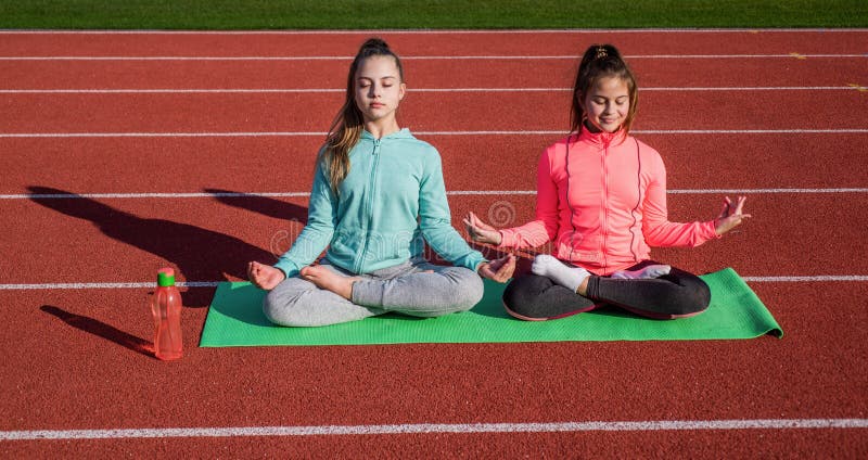 Yoga gives energy. teenage girls practicing yoga on mat outdoor. meditation. be in harmony with body. fitness warming up