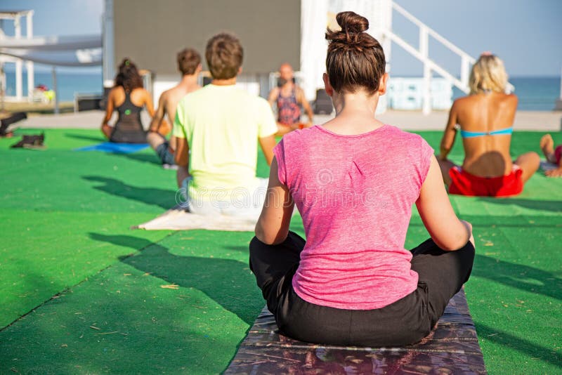 Yoga in het park, jonge vrouw die oefeningen met groep gemengde leeftijdsmensen doen royalty-vrije stock foto Yoga in het park, jonge vrouw die oefeningen met groep gemengde leeftijdsmensen doen royalty-vrije stock foto