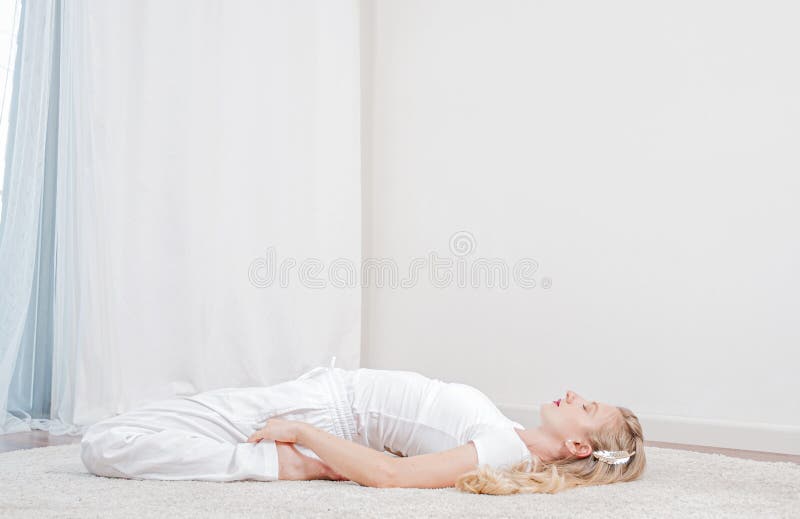 yoga La bella donna sta praticando l'yoga a casa, ragazza che fa la posa di Supta Virasanaexercise immagini stock yoga La bella donna sta praticando l'yoga a casa, ragazza che fa la posa di Supta Virasanaexercise immagini stock