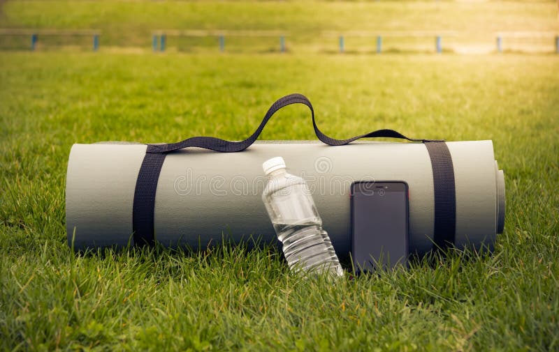 Yoga Mat with Water Bottle and Phone on Green Grass in the Soft Light Stock Image Image of