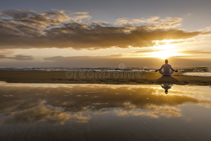 Yoga meditation silhouette lotus sunrise beach, water reflection of man in yoga pose, mindfulness wellbeing concept