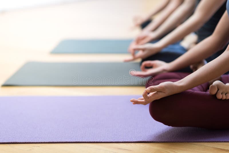 Yoga and mindfulness meditation. Women practicing yoga together and sitting in the lotus pose: mindfulness meditation, spirituality and healthy lifestyle concept stock photos