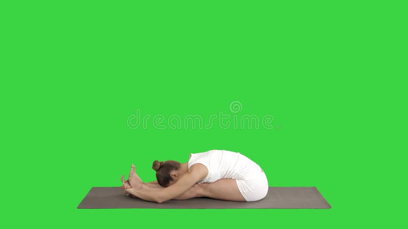 Yoga practicante de la mujer atractiva deportiva joven, haciendo ejercicio delantero asentado de la curva, actitud del paschimott