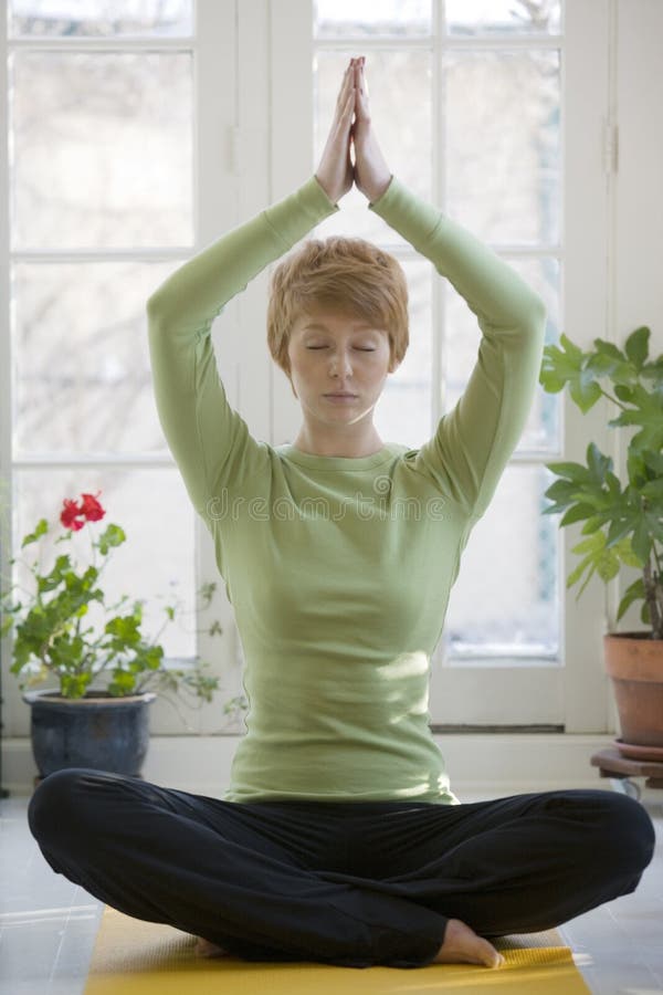 Yoga practicante de la mujer bastante joven imagen de archivo Yoga practicante de la mujer bastante joven imagen de archivo