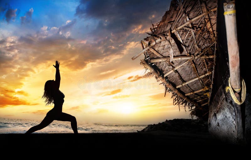 Yoga silhouette warrior pose near boat