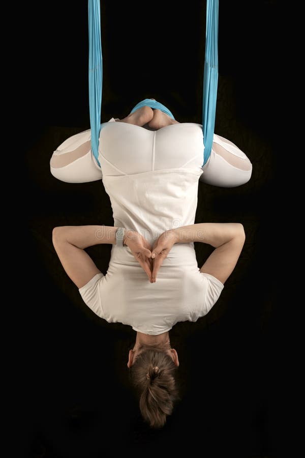 Yoga teacher demonstrates inverted asanas during fly yoga. Girl practices anti-gravity yoga upside down stock image