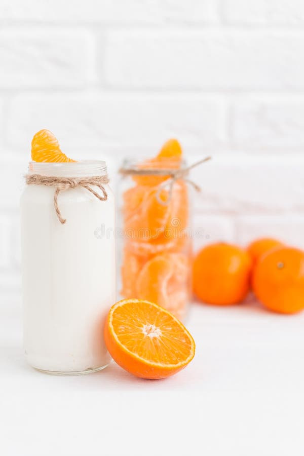 Yoghurt med nya orange skivor och hela apelsiner arkivbilder Yoghurt med nya orange skivor och hela apelsiner arkivbilder