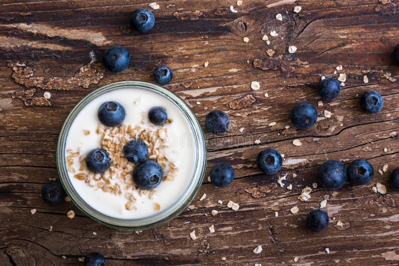 Yoghurt met Verse Bosbessen op Woden-Lijst stock foto Yoghurt met Verse Bosbessen op Woden-Lijst stock foto