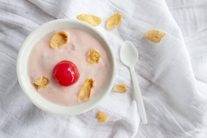 Yoghurt, röd körsbär och torkad havre i den vita bunken med skeden på bordduk royaltyfri bild Yoghurt, röd körsbär och torkad havre i den vita bunken med skeden på bordduk royaltyfri bild