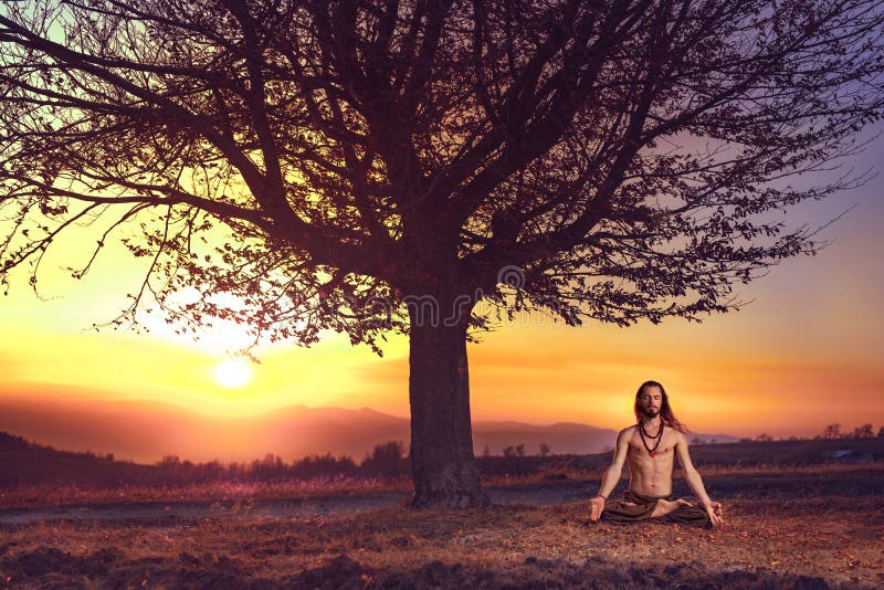 Yogi man meditating at sunset on the hills. Lifestyle relaxation emotional concept spirituality harmony with nature