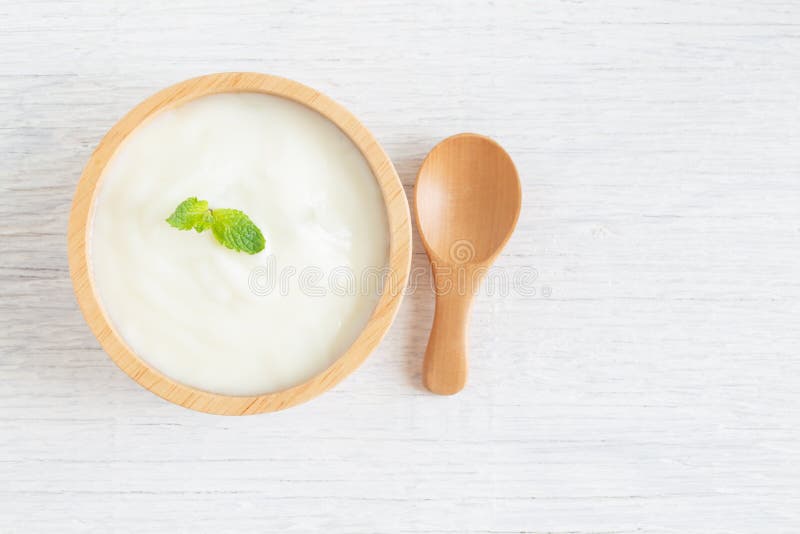 Yogur en el cuenco de madera en concepto sano de la comida de la tabla de madera blanca, la visión superior y el espacio de la co imágenes de archivo libres de regalías Yogur en el cuenco de madera en concepto sano de la comida de la tabla de madera blanca, la visión superior y el espacio de la co imágenes de archivo libres de regalías