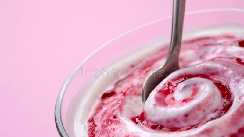 Yogurt with berry jam in spoon, blueberry whipped cream