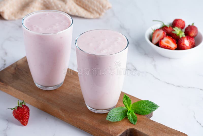 Yogurt , buttermilk or kefir with strawberry. Yogurt in glass on light background. Probiotic cold fermented dairy drink