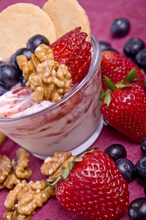 Yogurt cup with fresh fruits, cookies and nuts stock images