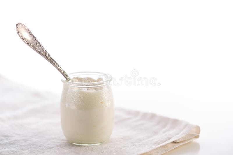 Yogurt in glass jar with spoon