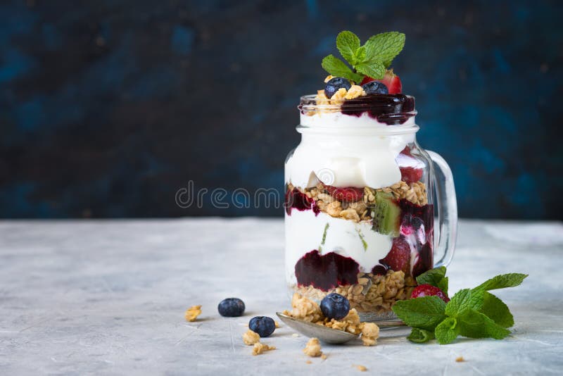 Yogurt granola jam berries dessert in mason glass jar.