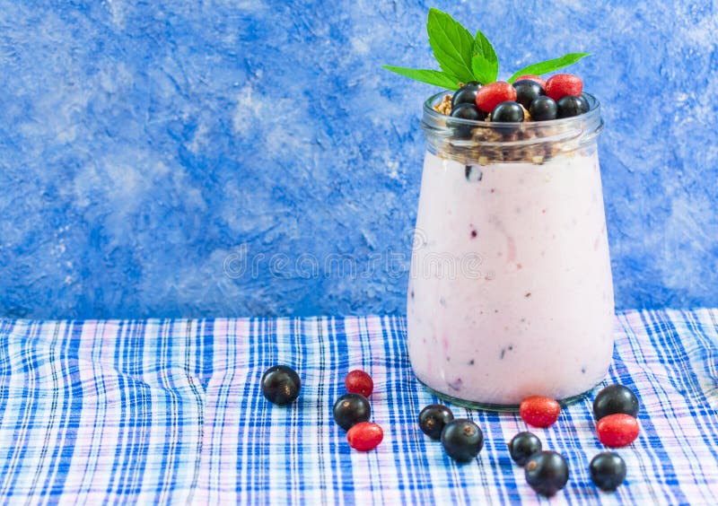 Yogurt with muesli and berries blueberries and raspberries, decorated with mint leaves on the table. Copy space. stock photo Yogurt with muesli and berries blueberries and raspberries, decorated with mint leaves on the table. Copy space. stock photo