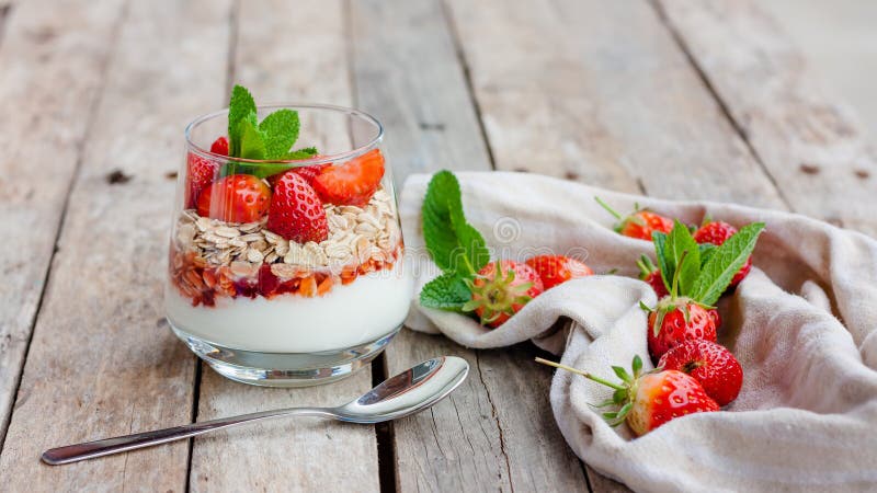 Yogurt with muesli and strawberries for healthy breakfast or snack. Strawberry dessert parfait with yogurt and granola.