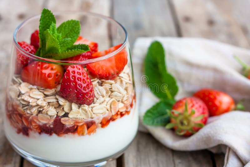 Yogurt with muesli and strawberries for healthy breakfast or snack. Strawberry dessert parfait with yogurt and granola.