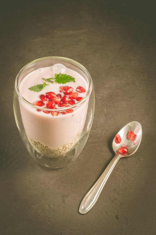 Yogurt. Sweet organic dessert with yogurt, garnet and mint in beautiful glasses on dark background. Selective focus stock photo Yogurt. Sweet organic dessert with yogurt, garnet and mint in beautiful glasses on dark background. Selective focus stock photo