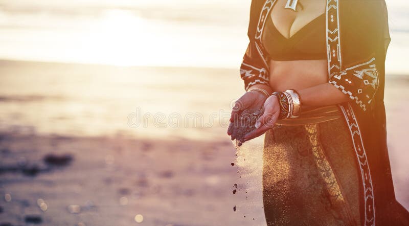 When you find yourself, youll be free. a young woman on the beach holding sand in her hands. royalty free stock images