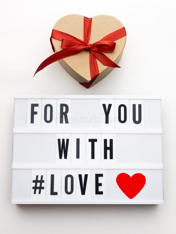 FOR YOU WITH LOVE word on lightbox on knit background with wrapped gifts boxes. Valentine`s day concept.