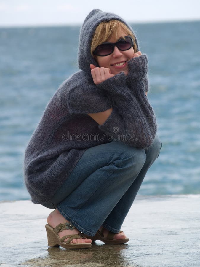 Youn Lady in Hood Sitting near Sea