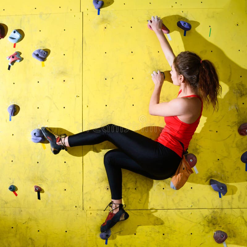 Young Active Woman Bouldering on Colorful Artificial Rock in Climbing Gym. Extreme Sport and Indoor Climbing Concept