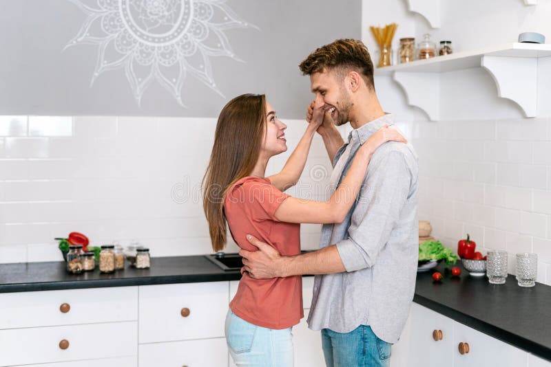 Young Adult Husband And Wife Dancing On Kitchen Stock Photo