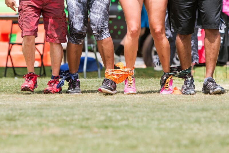 Young Adult Legs Walk In Unison At Five-Legged Race