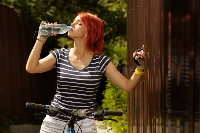 Young adult smiling biker woman on mounting bike