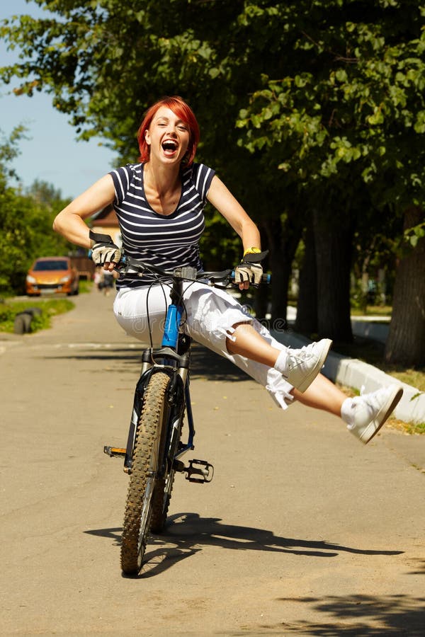 Young adult smiling biker woman on mounting bike