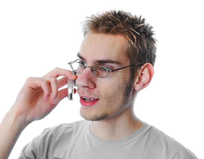 Young 18 year old adult teenager talks on his miniature 3G cellular phone isolated on white background while looking to the side weaing glasses. Young 18 year old adult teenager talks on his miniature 3G cellular phone isolated on white background while looking to the side weaing glasses