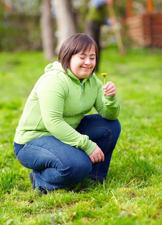 Young adult woman with disability enjoying nature in spring garden