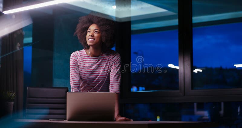 Black businesswoman using a laptop in night startup office