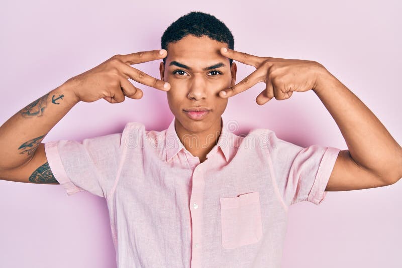 Young african american guy doing victory sign and peace gesture skeptic and nervous, frowning upset because of problem royalty free stock photo