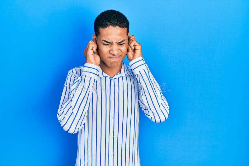 Young african american guy wearing casual clothes covering ears with fingers with annoyed expression for the noise of loud music royalty free stock photos