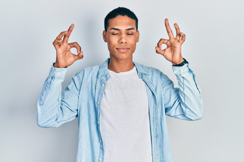 Young african american guy wearing casual clothes relax and smiling with eyes closed doing meditation gesture with fingers royalty free stock images