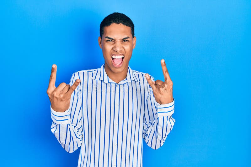 Young african american guy wearing casual clothes shouting with crazy expression doing rock symbol with hands up royalty free stock image