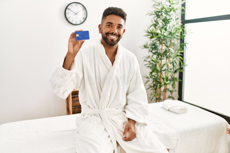 Young african american holding credit card at beauty center stock photos