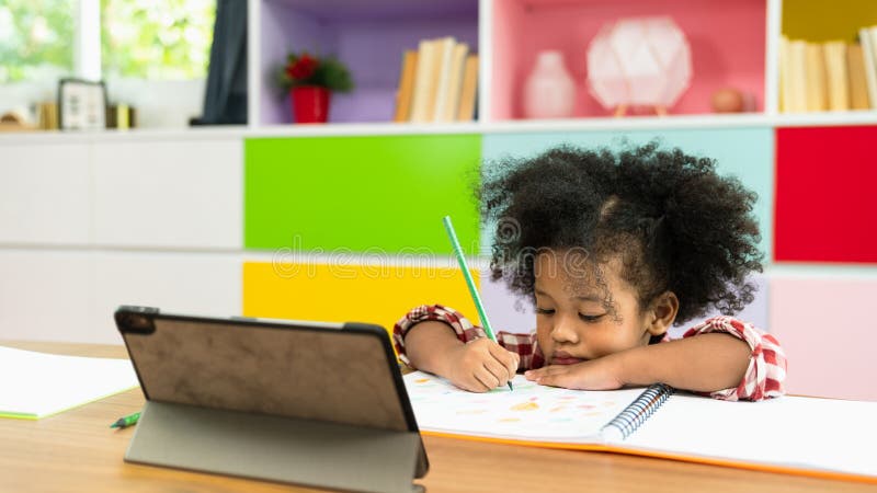 Young African American kid girl studying using digital tablet, preschool child study at home school. homeschooling concept