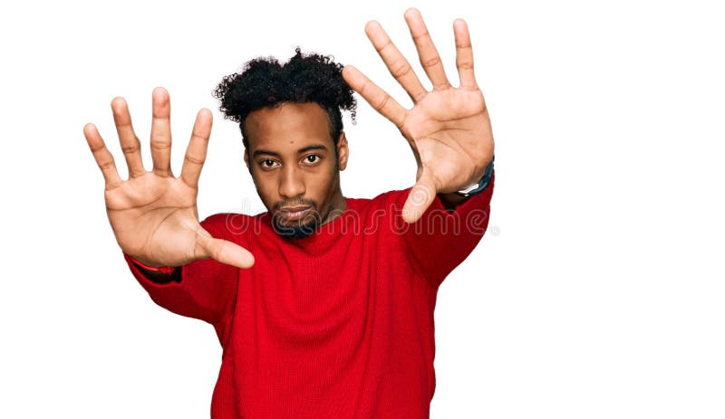 Young african american man with beard wearing casual winter sweater doing frame using hands palms and fingers, camera perspective
